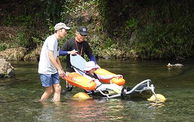 水陸両用車いす（モビチェア）で川に入水している様子