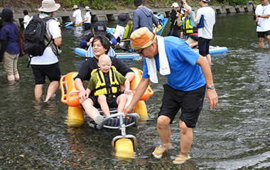 水陸両用車いす（モビチェア）で川に入水している様子