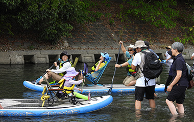 大型SUPボートで車いす利用者と視覚障害者が「SUP体験」にチャレンジする様子