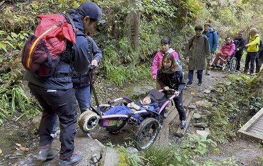 急斜面で車いすをサポートする様子