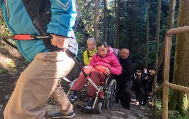 急斜面で車いすをサポートする様子