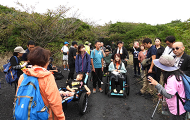 トレッキングコースで車いすをサポートする様子